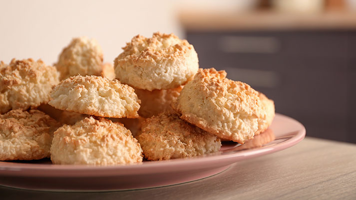 Plate with delicious coconut macaroons on table