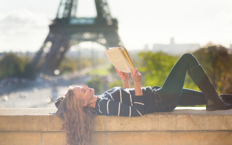 Girl reading a book in Paris on a sunny day